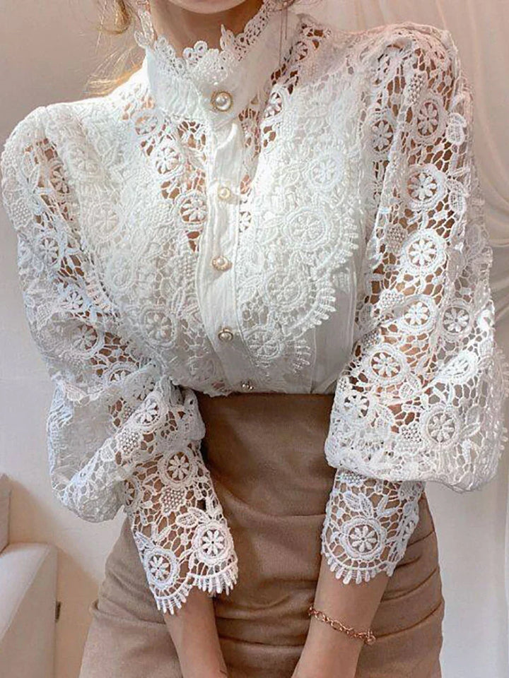Blusa in pizzo bianco elegante con maniche lunghe e dettagli floreali, colletto alto, bottoni decorativi, perfetta per moda donna e abbigliamento formale.