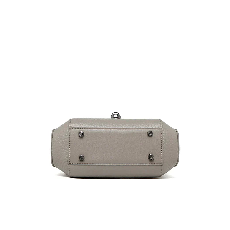 Borsa a tracolla in pelle grigia, vista dal basso, con piedini metallici. Design elegante e moderno, ideale per moda donna e accessori di lusso.
