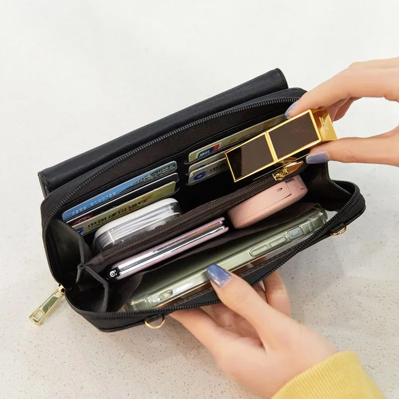 Portafoglio nero aperto con carte di credito, smartphone, rossetto e accessori. Design elegante, multifunzionale, ideale per organizzazione quotidiana.