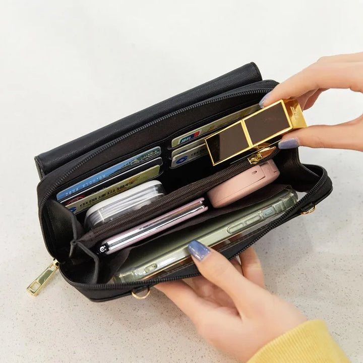 Portafoglio nero aperto con carte di credito, smartphone, rossetto e accessori. Design elegante, multifunzionale, ideale per organizzazione quotidiana.