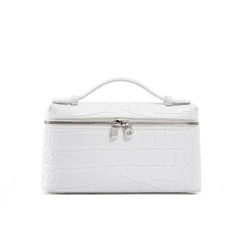 Borsa cosmetica bianca in pelle effetto coccodrillo con manico superiore e chiusura a zip. Elegante e pratica per viaggi e organizzazione.
