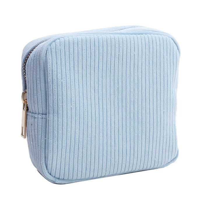 Astuccio quadrato in tessuto a coste azzurro con cerniera dorata, ideale per cosmetici o accessori. Design elegante e pratico per l'uso quotidiano.
