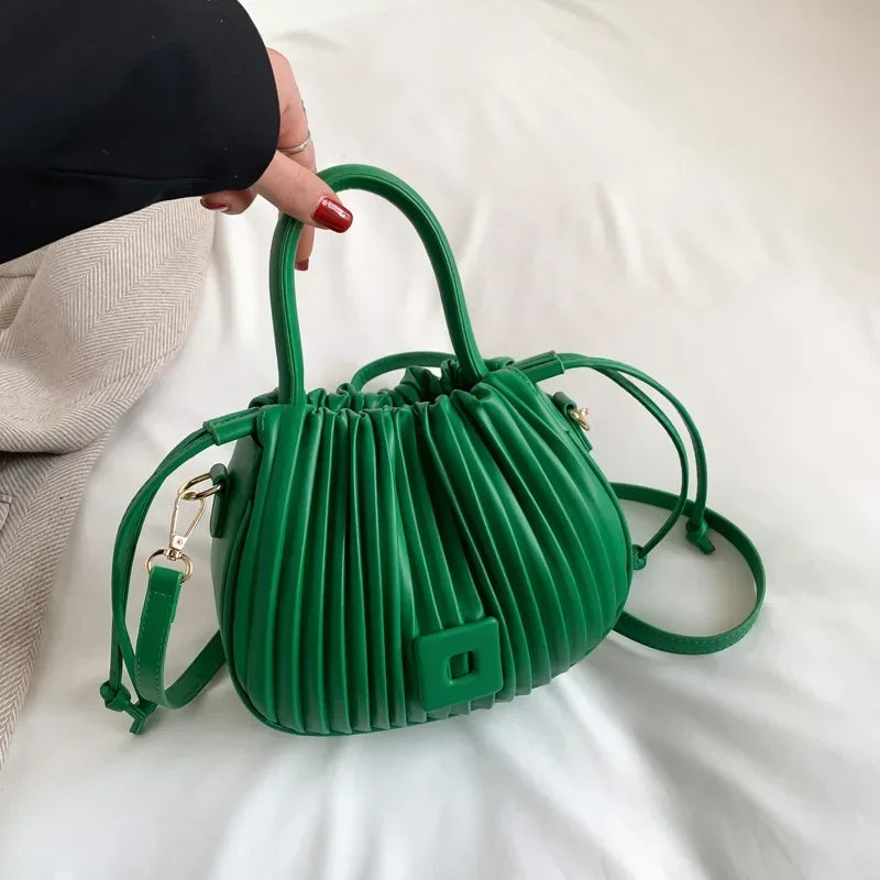 Borsa a mano verde pieghettata con tracolla regolabile, design moderno, chiusura a bottone, ideale per moda femminile e accessori eleganti.