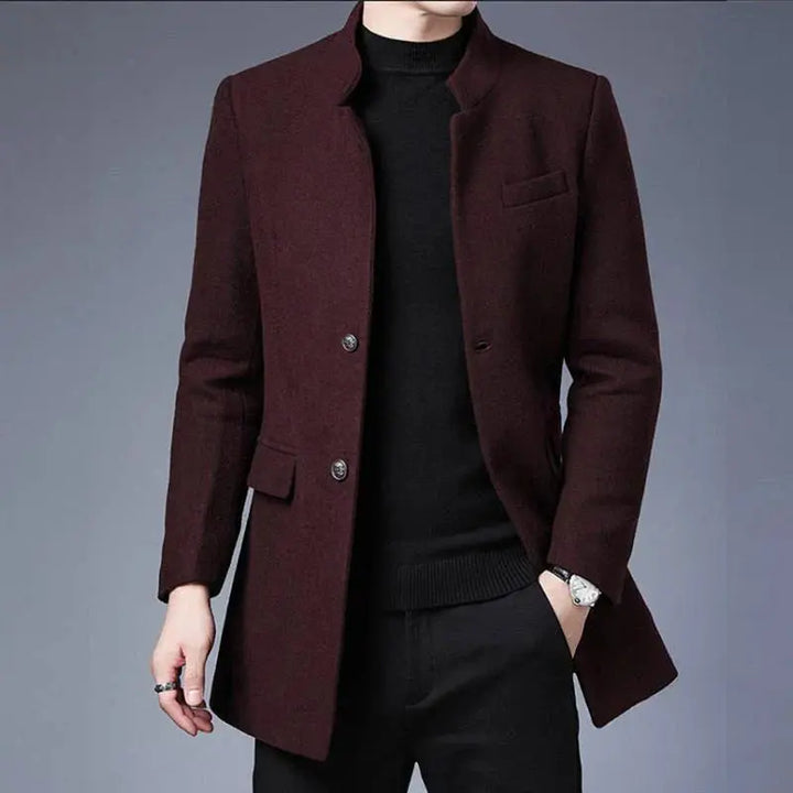 Cappotto uomo elegante marrone scuro, stile moderno, con bottoni, tasche frontali, indossato su maglione nero. Moda autunnale invernale.