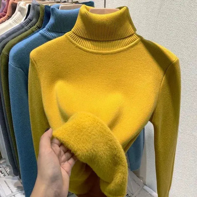 Maglione dolcevita giallo in lana morbida, esposto su appendiabiti con vari colori. Moda autunno inverno, abbigliamento caldo e confortevole.