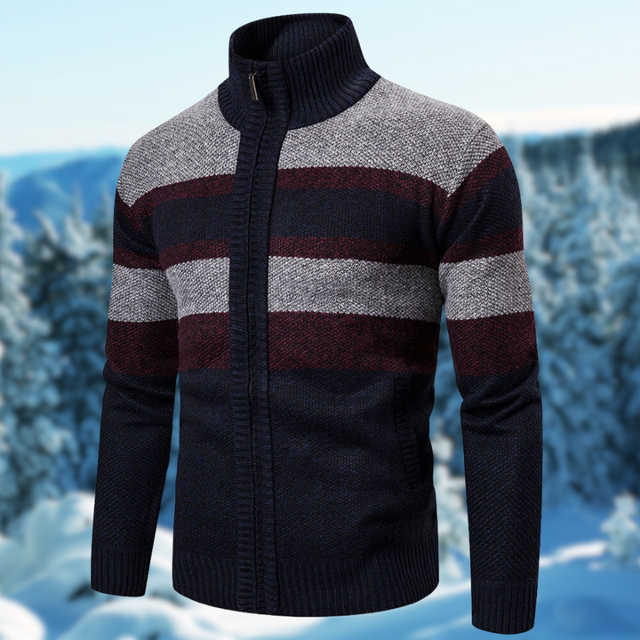 Maglione invernale da uomo a righe blu, grigie e bordeaux, con zip e collo alto, sfondo innevato. Maglione caldo e alla moda per l'inverno.