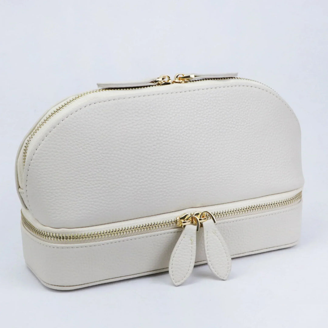 Elegante borsa cosmetica in pelle bianca con doppia cerniera dorata, design moderno e spazioso, ideale per viaggi e organizzazione trucco.