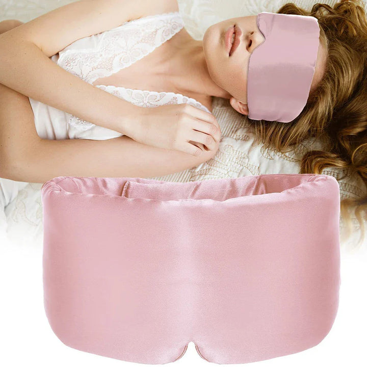 Donna che indossa maschera per dormire in seta rosa, rilassata su letto. Mascherina notte morbida, accessorio sonno, comfort, relax.