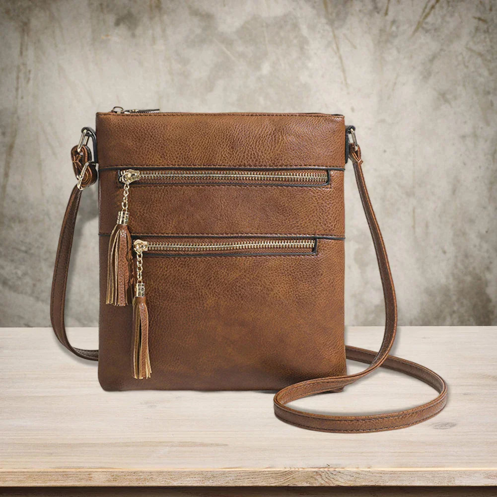 Borsa a tracolla in pelle marrone con cerniere e nappine, design elegante e pratico, ideale per moda donna, accessori casual chic.