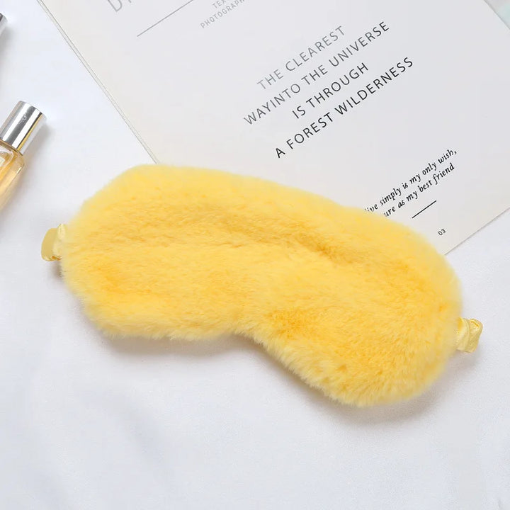 Maschera per dormire in pelliccia sintetica gialla su sfondo bianco, accessorio per il sonno, morbida e confortevole, ideale per relax e viaggi.