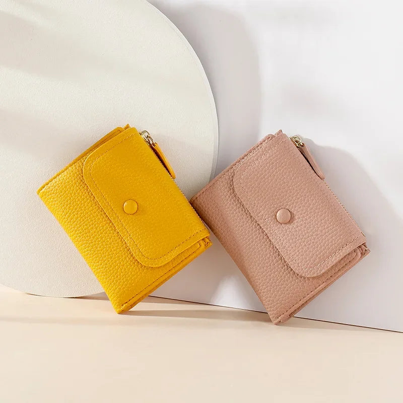 Portafogli donna in pelle sintetica, colori giallo e rosa, design compatto con chiusura a bottone, accessori moda eleganti e pratici.