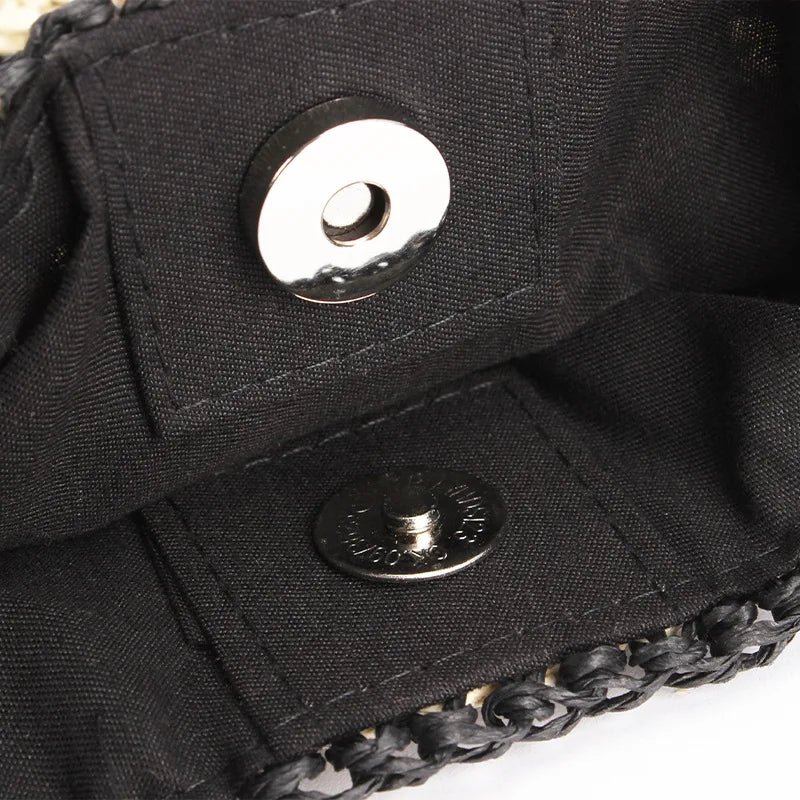 Interno di una borsa in tessuto nero con chiusura magnetica, dettagli intrecciati. Accessorio moda elegante, ideale per eventi e uscite serali.