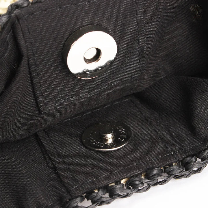 Interno di una borsa in tessuto nero con chiusura magnetica, dettagli intrecciati. Accessorio moda elegante, ideale per eventi e uscite serali.