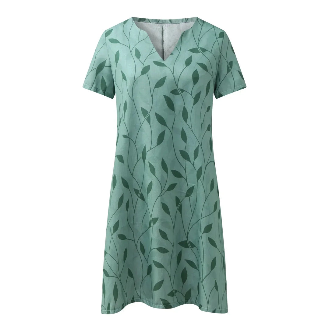 Abito estivo verde con motivo a foglie, maniche corte, scollo a V. Vestito casual donna, tessuto leggero, ideale per la moda estiva.
