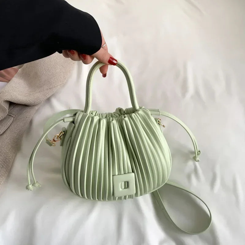 Borsa a mano verde pastello in pelle plissettata, design elegante e moderno, con manico e tracolla regolabile. Accessorio moda donna.