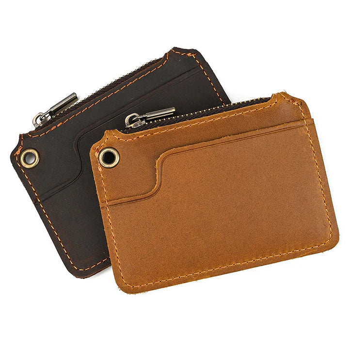 Due portafogli in pelle minimalista, uno marrone e uno nero, con cerniera e tasche per carte. Design elegante e compatto per uomo e donna.