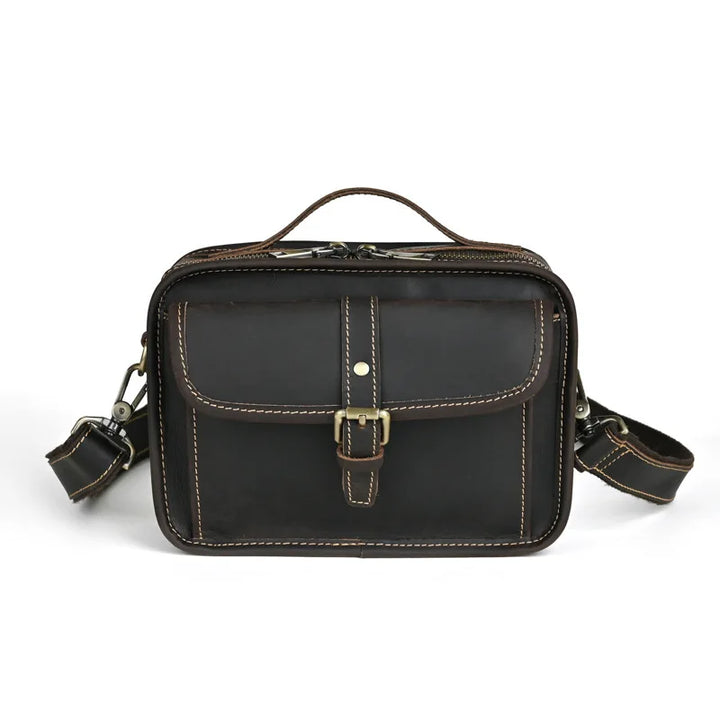 Borsa a tracolla in pelle marrone scuro con fibbia, tasca frontale e cuciture a contrasto. Elegante e resistente, ideale per uomo e donna.