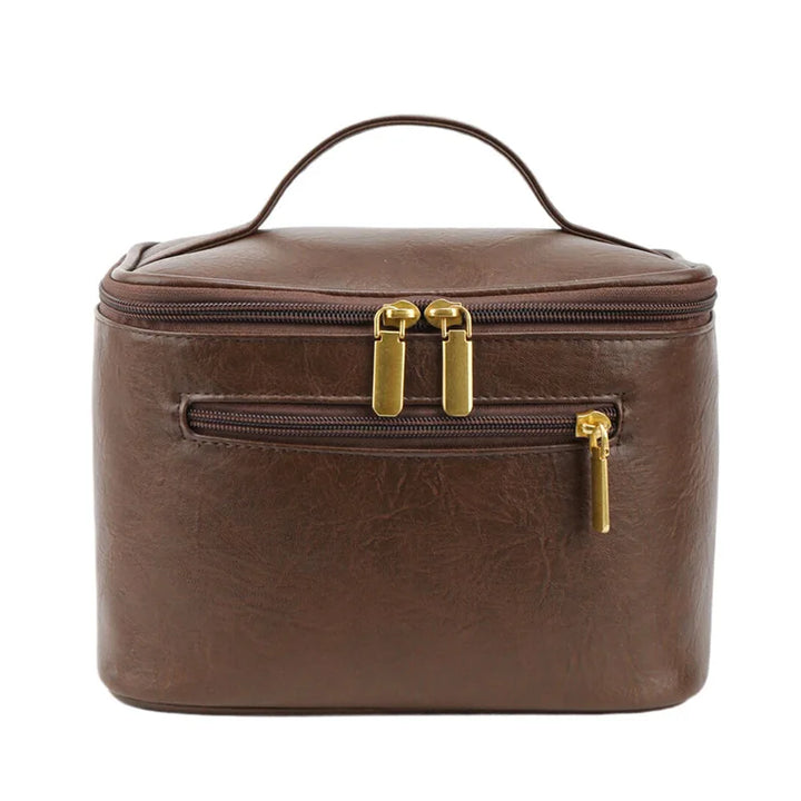 Borsa cosmetica marrone in pelle sintetica con cerniere dorate, manico superiore, tasca frontale. Elegante e pratica per viaggi e organizzazione.