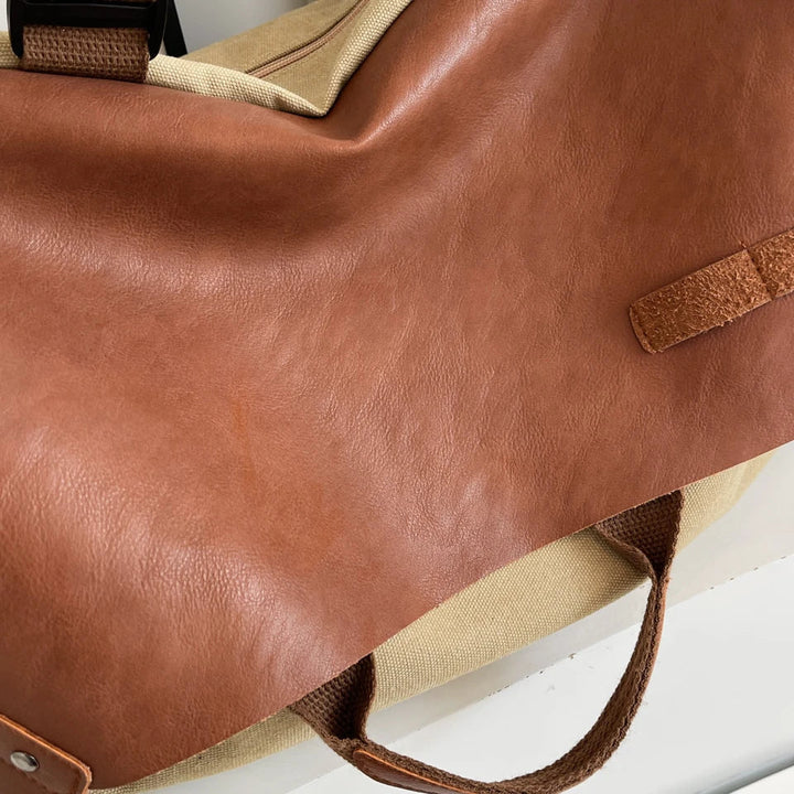 Borsa da viaggio in pelle marrone e tessuto beige, manici robusti, design elegante, ideale per viaggi e uso quotidiano. Accessorio moda versatile.