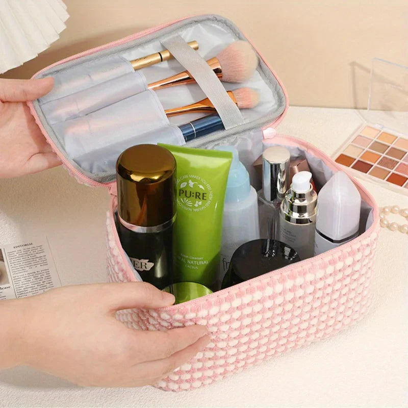 Astuccio cosmetico rosa con pennelli trucco, creme e prodotti skincare. Organizer da viaggio per cosmetici, accessori bellezza, trucco.