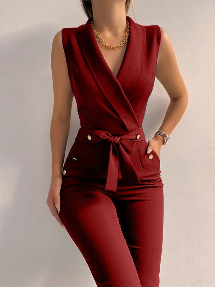 Tuta elegante donna rosso bordeaux, senza maniche, con cintura annodata e bottoni dorati, ideale per eventi formali e moda autunnale.
