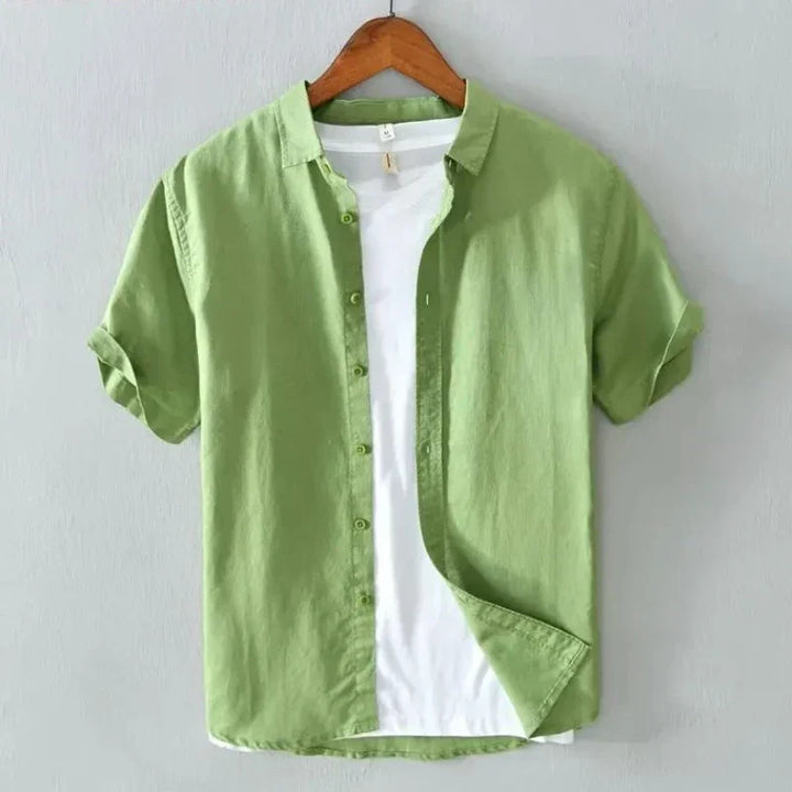 Camicia verde a maniche corte in cotone, stile casual, con colletto classico, abbinata a t-shirt bianca. Ideale per moda estiva uomo.