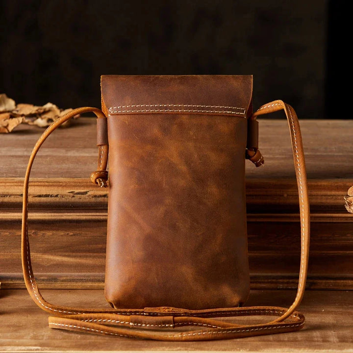 Borsa a tracolla in pelle marrone vintage, design elegante e compatto, ideale per uomo e donna, perfetta per smartphone e accessori essenziali.