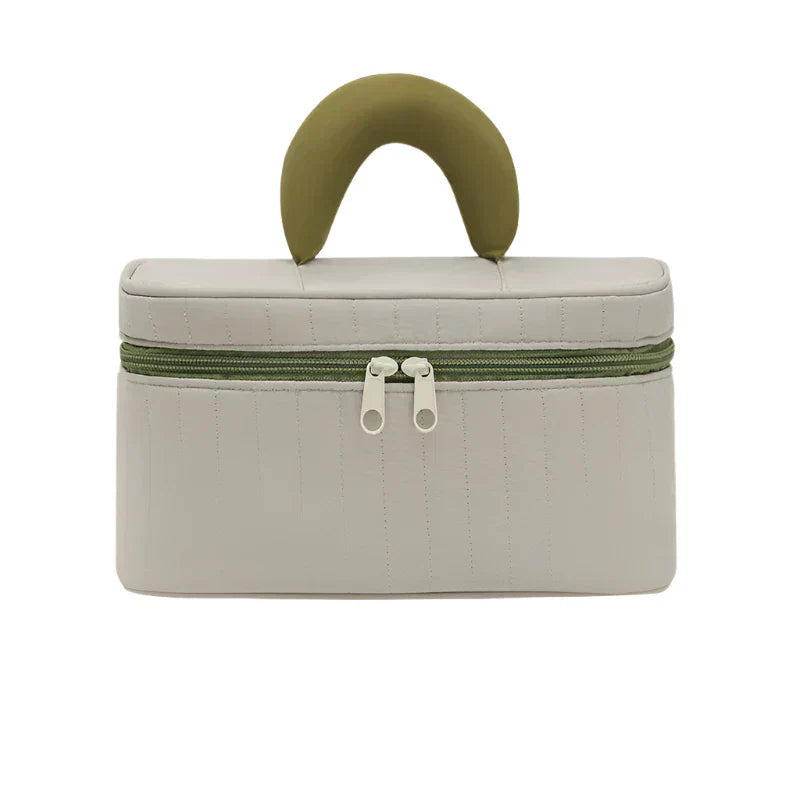 Borsa cosmetica beige con manico verde, chiusura a doppia zip, design elegante e compatto, ideale per viaggi e organizzazione trucco.