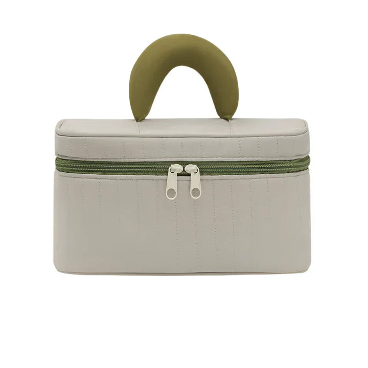 Borsa cosmetica beige con manico verde, chiusura a doppia zip, design elegante e compatto, ideale per viaggi e organizzazione trucco.