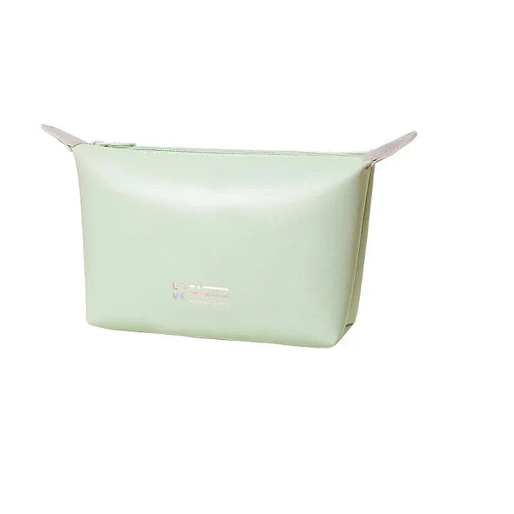 Astuccio cosmetico verde menta in pelle sintetica, design minimalista, chiusura a zip, ideale per trucchi e accessori da viaggio.