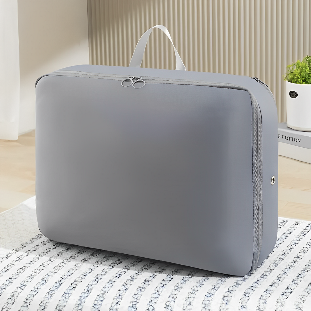 Valigia organizer grigia con manico, design compatto e moderno, ideale per viaggi e organizzazione, posizionata su un letto in una stanza luminosa.