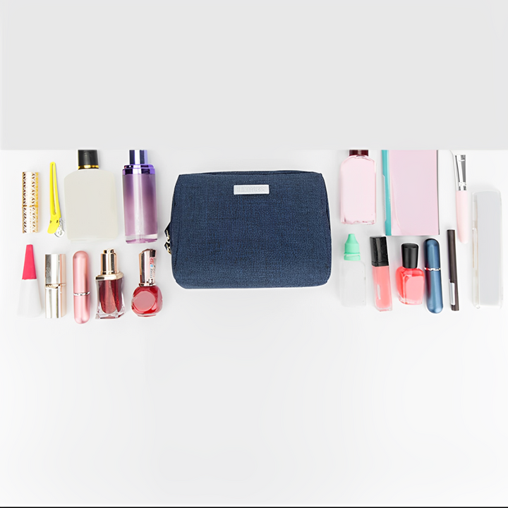 Astuccio cosmetico blu con vari prodotti di bellezza: rossetti, profumi, smalti e creme. Organizzatore trucco da viaggio, accessori moda donna.