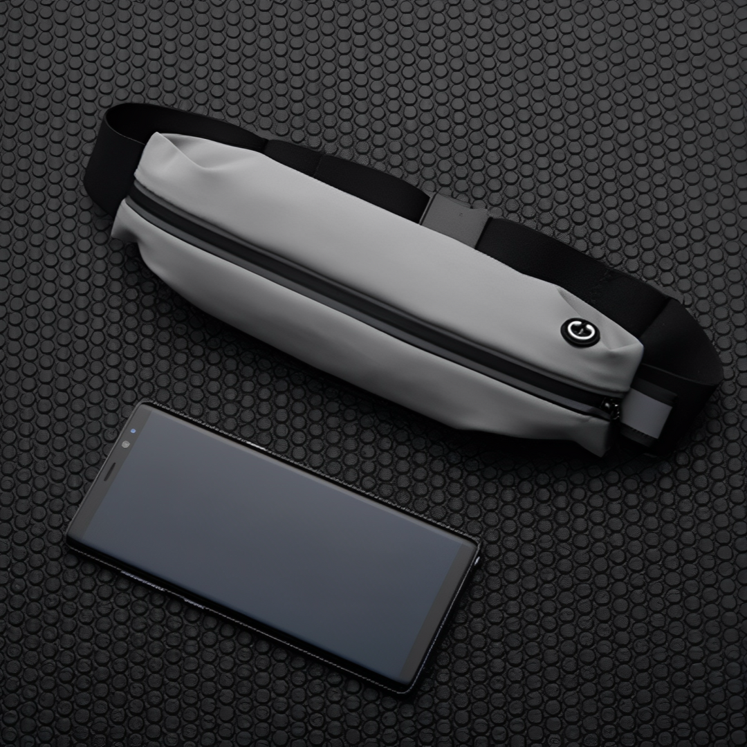 Marsupio grigio impermeabile con cerniera nera su sfondo a nido d'ape, accanto a smartphone nero. Accessorio moda pratico e moderno.