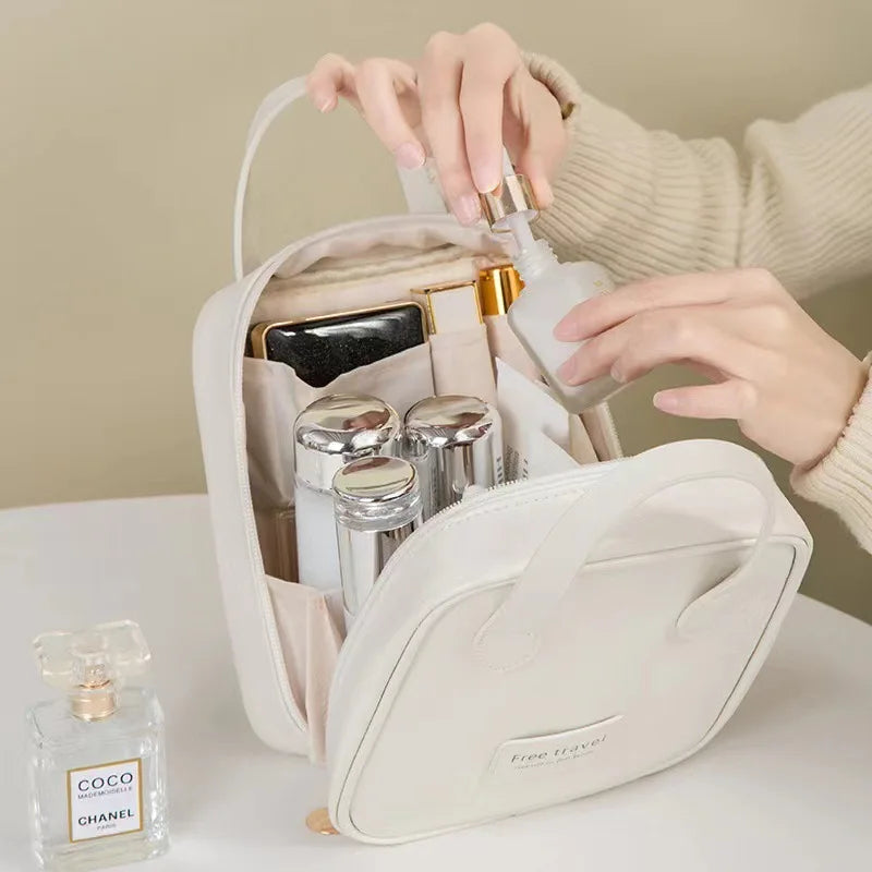 Borsa da viaggio bianca con flaconi cosmetici, profumo Chanel e mani femminili. Organizer cosmetici, accessori viaggio, beauty case elegante.