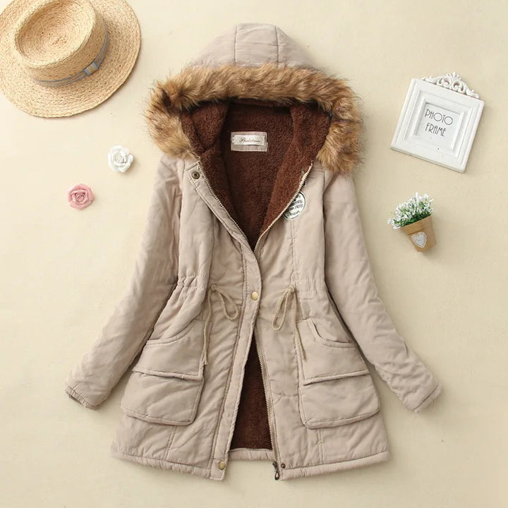 Giacca invernale beige con cappuccio e bordo in pelliccia sintetica, tasche frontali e chiusura a zip. Perfetta per moda donna autunno inverno.