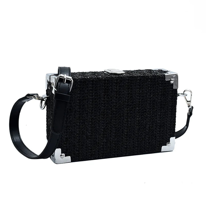 Borsa a tracolla nera rettangolare con dettagli in metallo argentato, design intrecciato, chiusura a scatto e tracolla regolabile. Elegante e moderna.