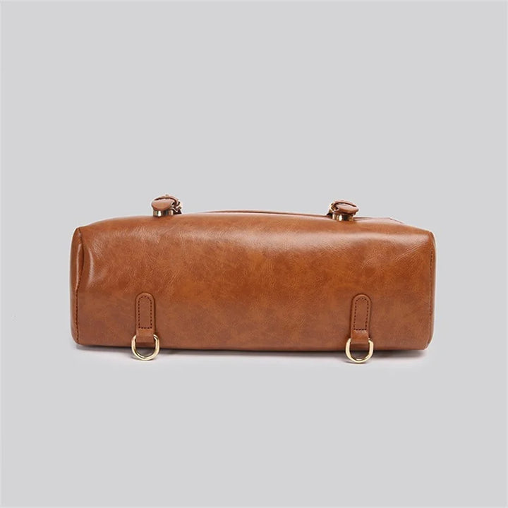 Borsa a tracolla in pelle marrone, design cilindrico, con anelli metallici dorati. Elegante accessorio moda donna, perfetto per ogni occasione.