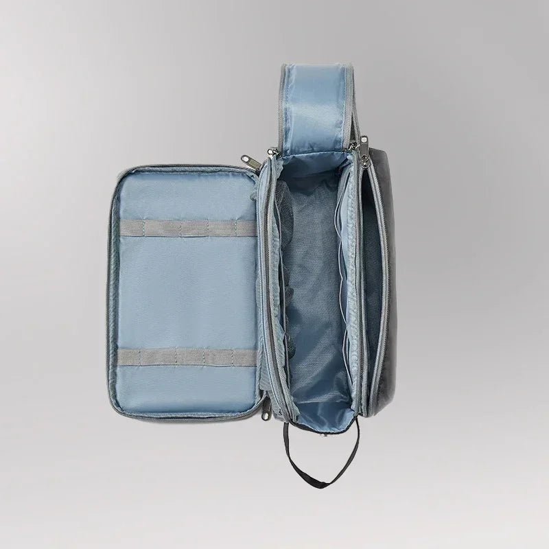 Zaino organizer grigio aperto, con scomparti multipli e tasche, ideale per viaggi e lavoro. Design moderno e funzionale.
