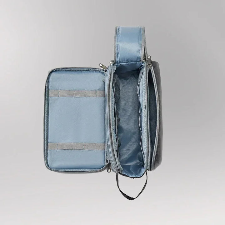 Zaino organizer grigio aperto, con scomparti multipli e tasche, ideale per viaggi e lavoro. Design moderno e funzionale.