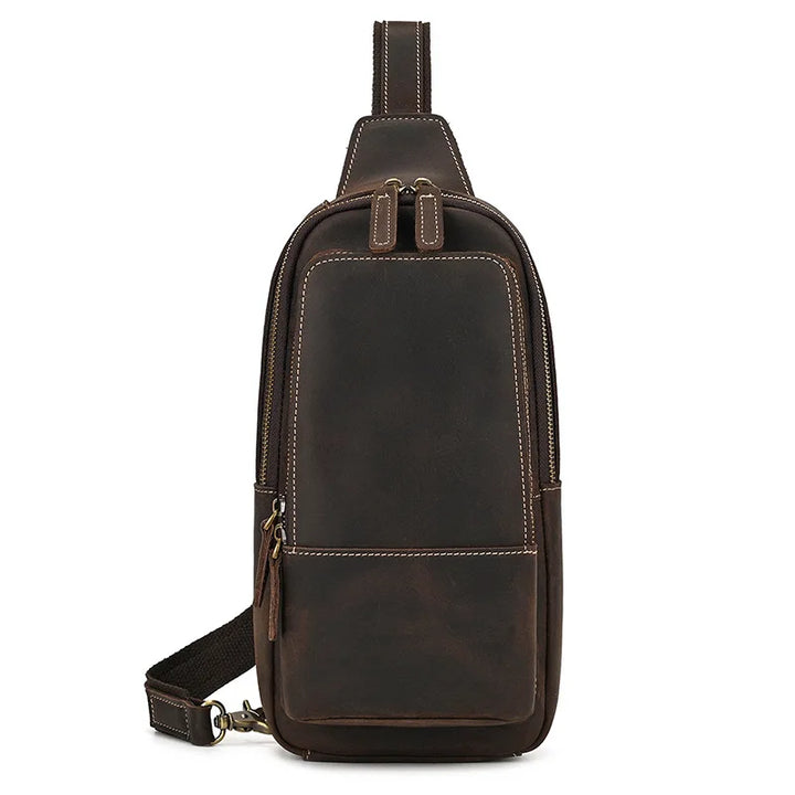 Zaino monospalla in pelle marrone scuro, design elegante e compatto, con cerniere robuste e tracolla regolabile. Ideale per uomo e donna.
