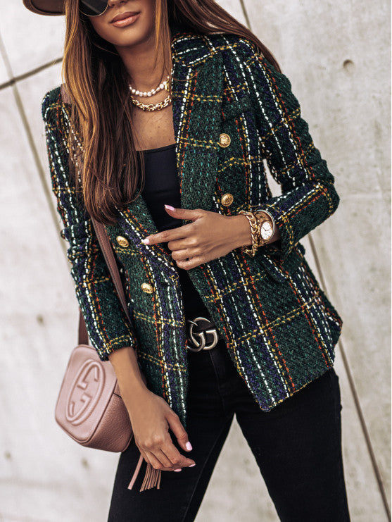 Donna con giacca a quadri verde, accessori dorati, borsa a tracolla rosa e cintura nera. Moda autunnale elegante e chic.