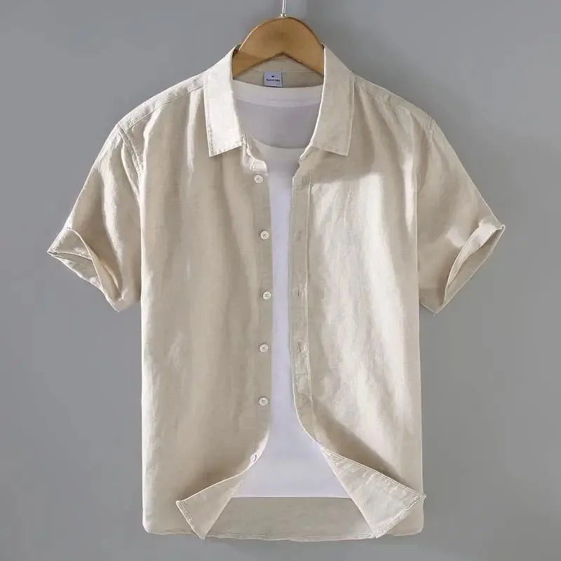 Camicia beige da uomo in lino, maniche corte, su gruccia. Design casual, perfetta per l'estate. Sfondo grigio chiaro.
