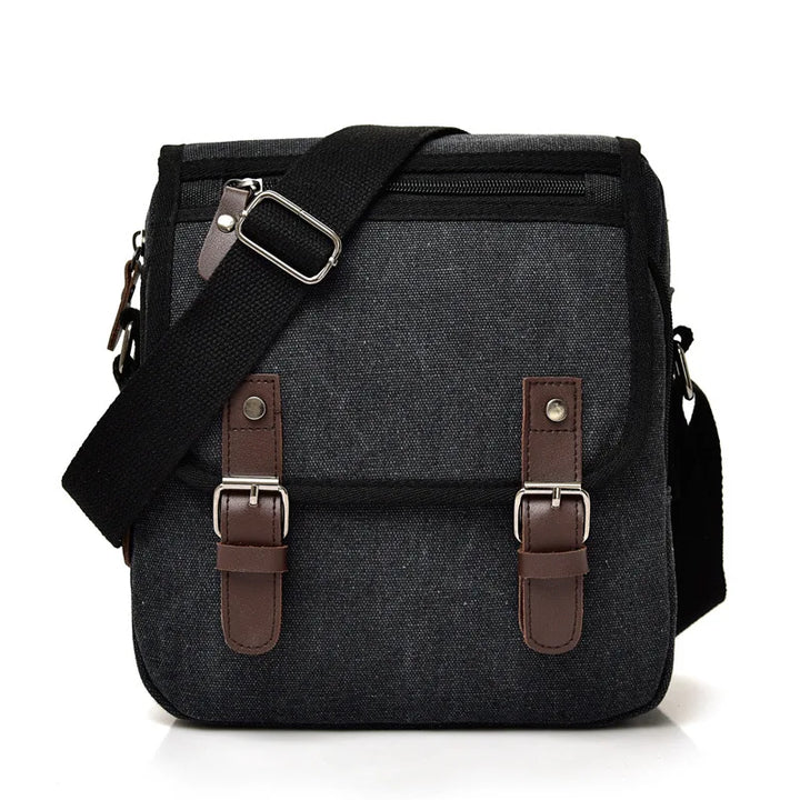 Borsa a tracolla in tela nera con fibbie marroni, tasca frontale con zip, ideale per uomo, stile casual, resistente e pratica per l'uso quotidiano.