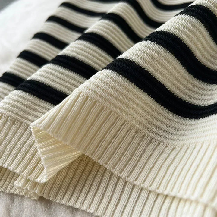 Maglione a righe bianche e nere in lana, tessuto a coste, dettaglio del bordo. Moda invernale, abbigliamento caldo, stile casual elegante.