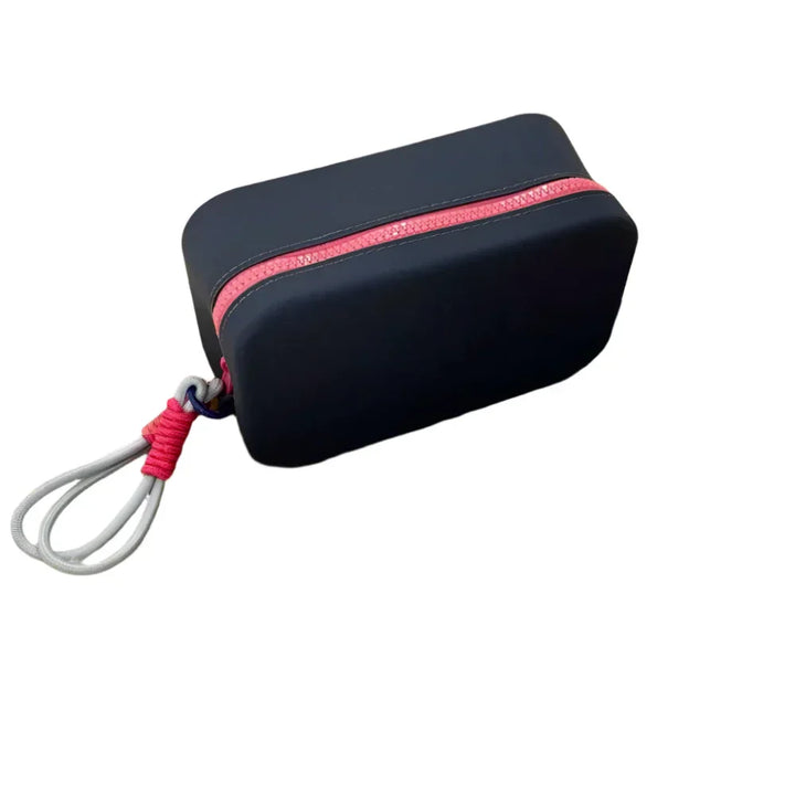 Custodia rigida nera con cerniera rossa e cordino grigio, ideale per protezione e trasporto di piccoli oggetti elettronici. Accessorio compatto e resistente.