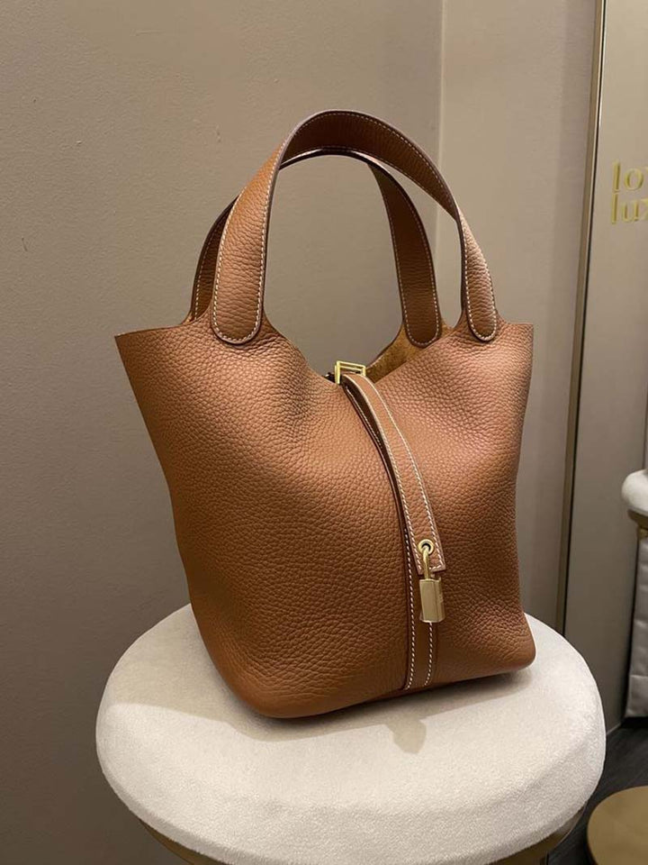 Borsa a mano in pelle marrone con chiusura a zip e lucchetto dorato, design elegante e moderno, perfetta per moda donna e accessori di lusso.