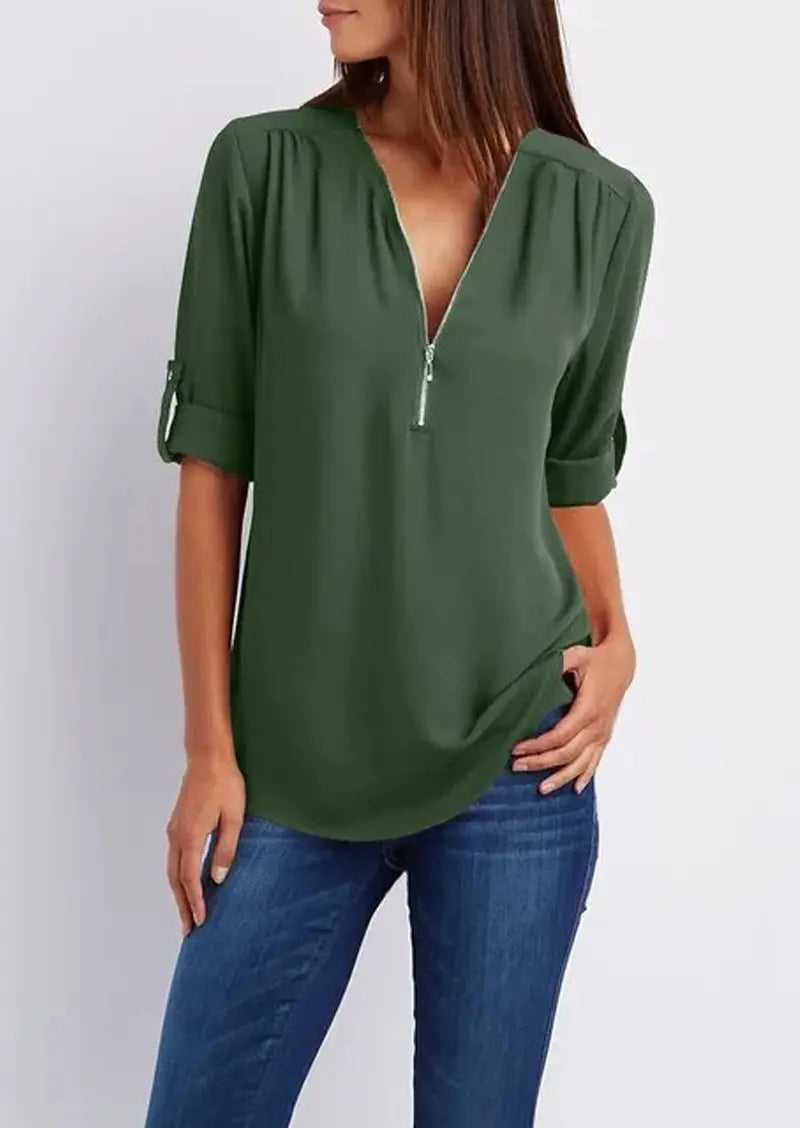 Blusa verde donna con zip, maniche a 3/4 arrotolate, scollo a V, abbinata a jeans. Moda casual elegante, abbigliamento femminile trendy.