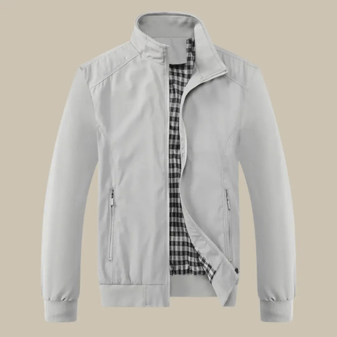 Giacca uomo grigia con fodera a quadri, zip frontale, colletto rialzato, tasche laterali. Elegante e versatile per ogni stagione.