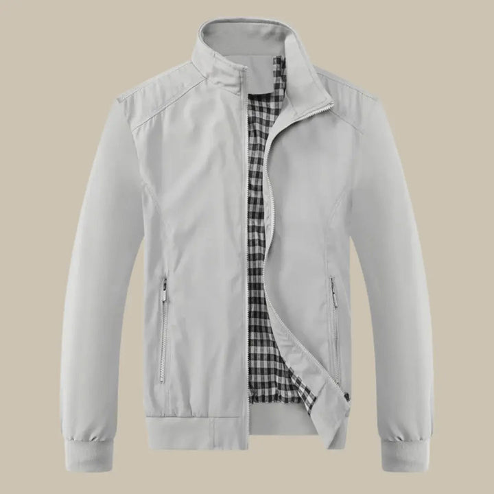 Giacca uomo grigia con fodera a quadri, zip frontale, colletto rialzato, tasche laterali. Elegante e versatile per ogni stagione.