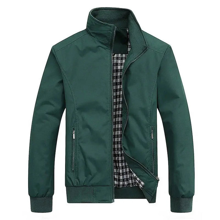 Giacca verde da uomo con cerniera, colletto alto e fodera a quadri. Design casual, ideale per autunno e primavera. Tasche laterali con zip.